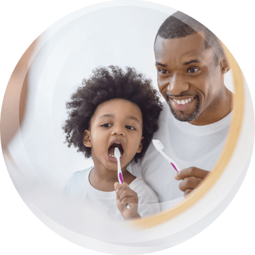 Dad and kid brushing teeth together.
